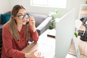 Portrait of a beautiful female interpreter doing an online translation from her office wearing a headset and talking to the screen